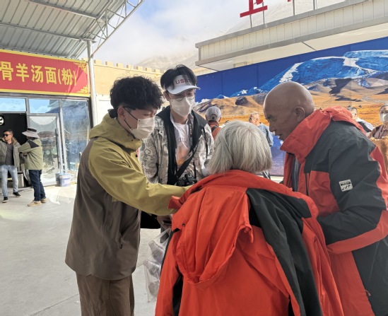 上理學(xué)子在紅其拉甫為老年游客提供幫助